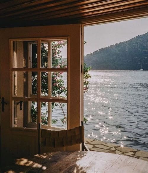 This may contain: an open window looking out onto the water