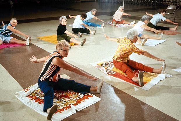 This may contain: a group of people doing yoga on the floor This may contain: a group of people doing yoga on the floor