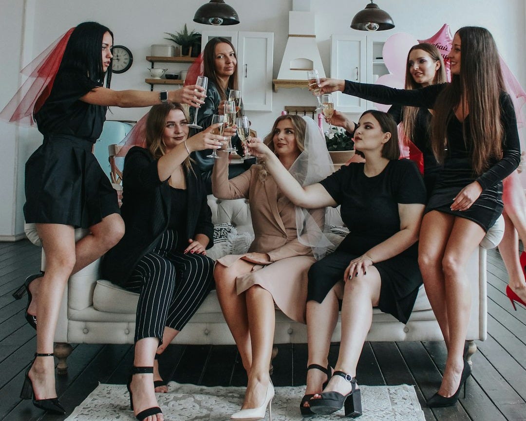 group of women sitting on white floor