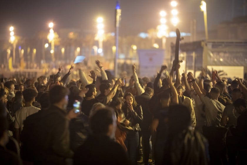Gente bailando en una multitud en la playa de Barcelona, España, el domingo 9 de mayo de 2021. 