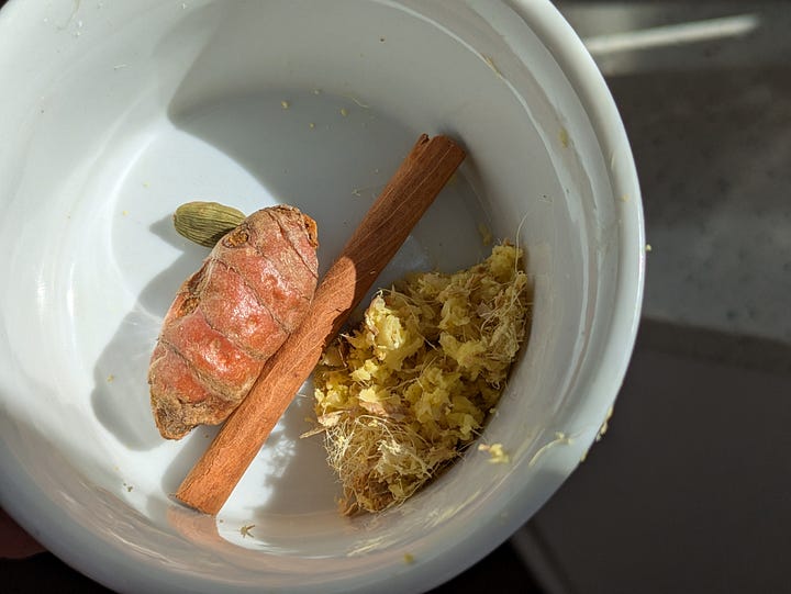 Fresh grated ginger with whole cinnamon, cardamom and turmeric.
