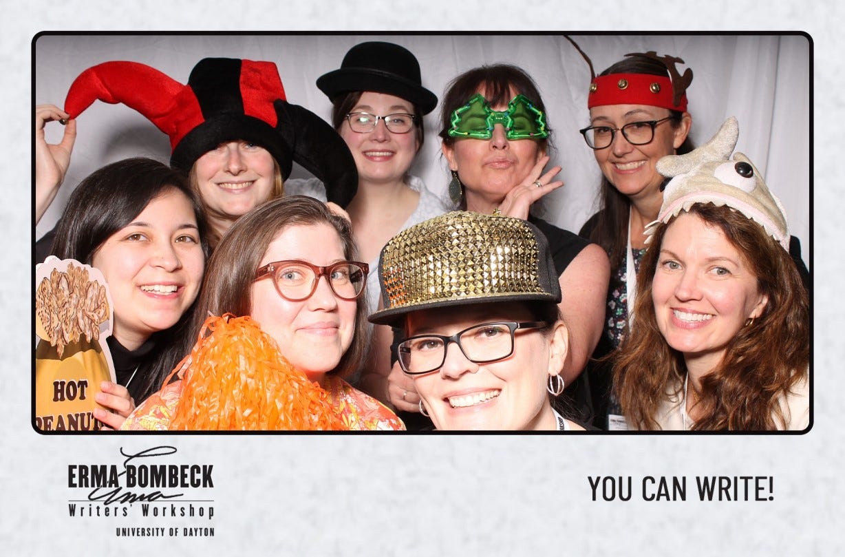 A group of women smile in a photobooth wearing funny hats and glasses