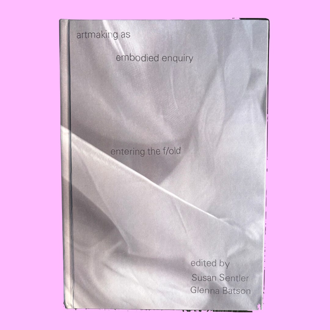The cover of this book looks like it's folded into a soft, light grey fabric.