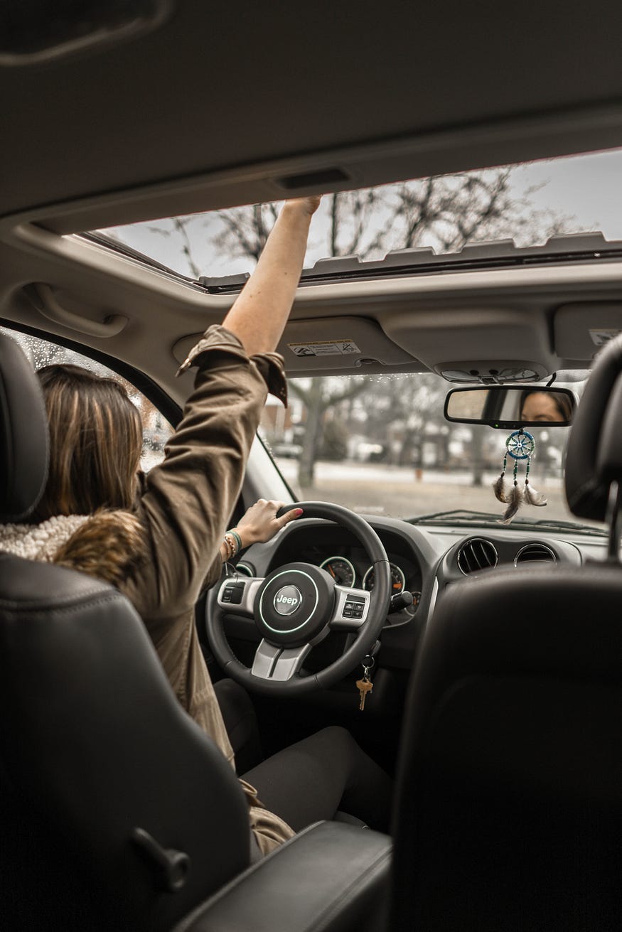 a woman driving her car. a woman driving her car.