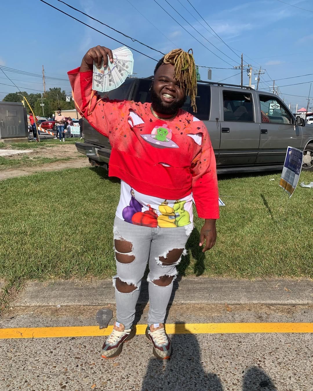 Baby Alien in a brown jacket and black shirt.