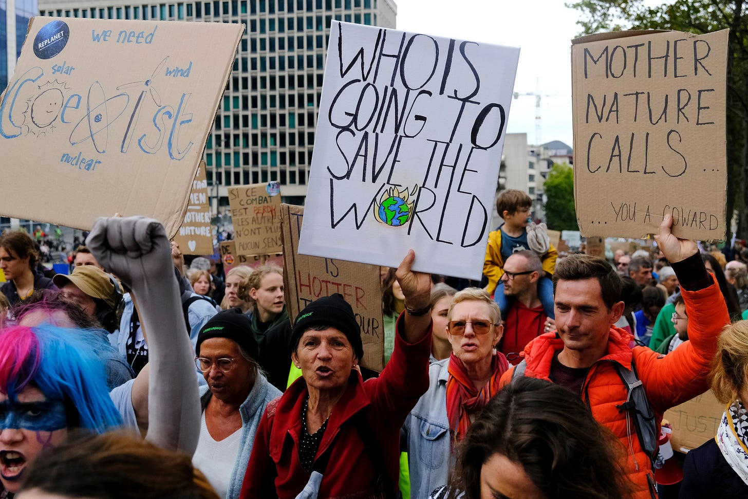People marching with their hands in the air holding cardboard signs. People marching with their hands in the air holding cardboard signs.