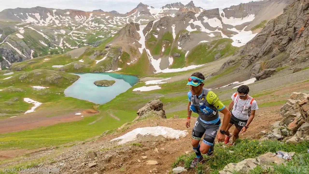 Runners hiking up above an alpine lake on the way to grant swamp pass.