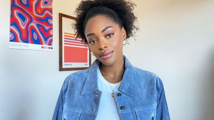 A Black woman smiles to the camera wearing pink lipstick A Black woman smiles to the camera wearing pink lipstick