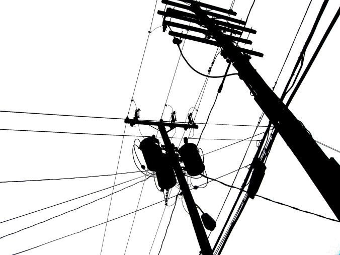 This may contain: black and white photograph of power lines, telephone poles and street lights against a gray sky