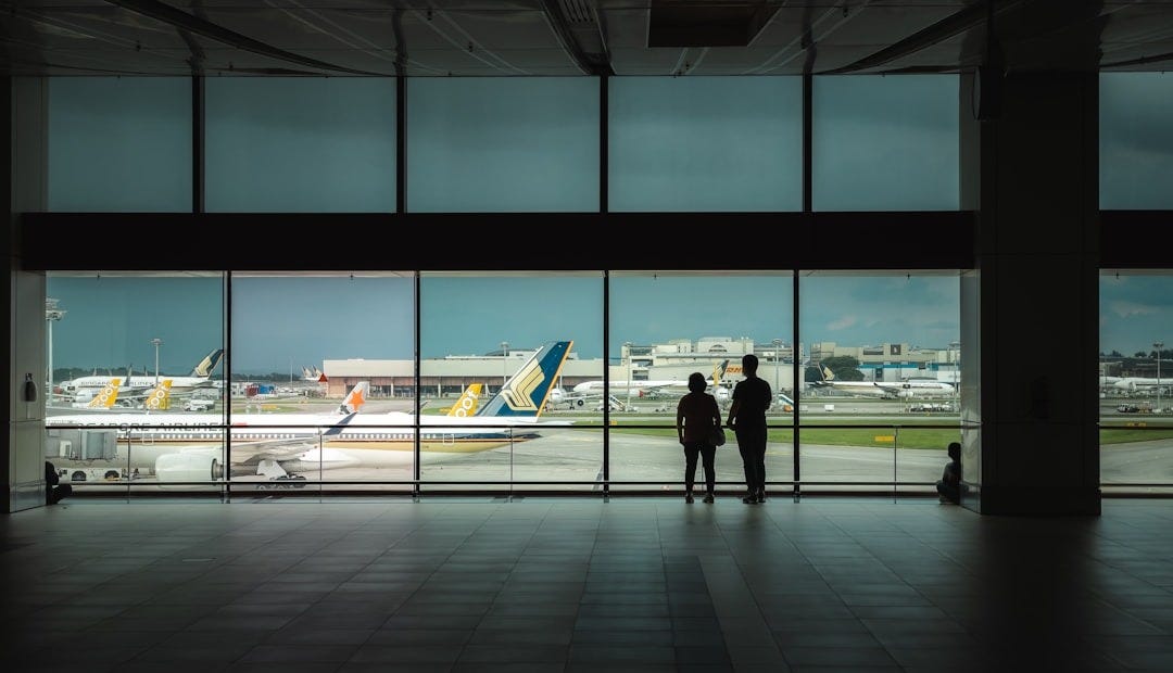 man in black jacket walking on sidewalk during daytime