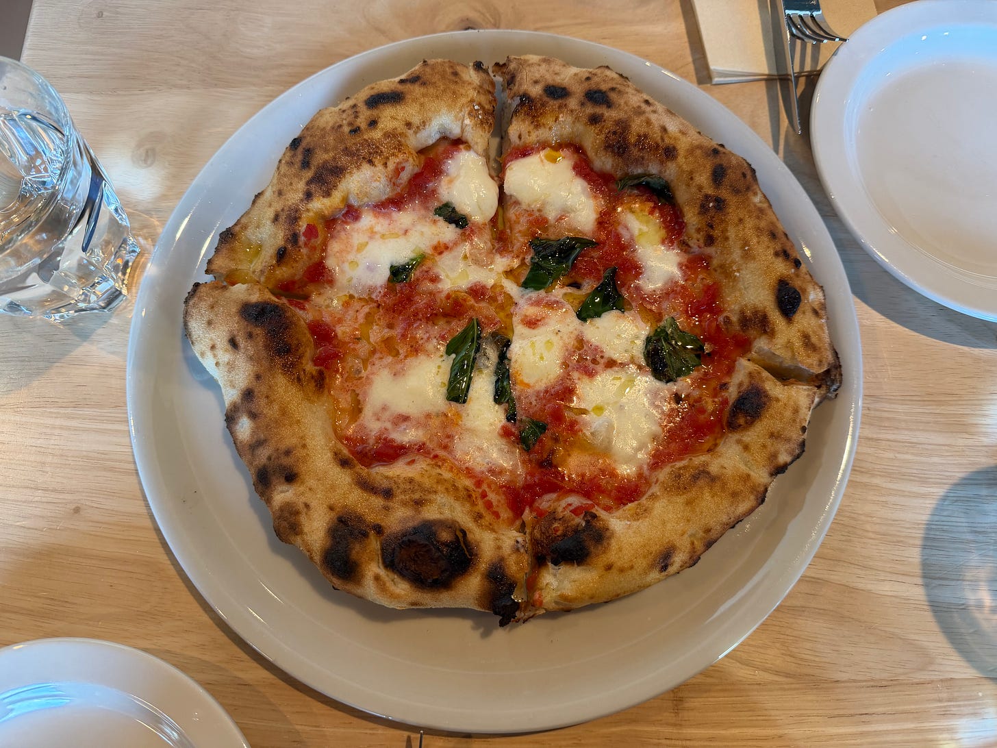 Wood-fired Margherita pizza with tomato, mozzerella, basil, and charred crust at Pizzeria Sei in Los Angeles.