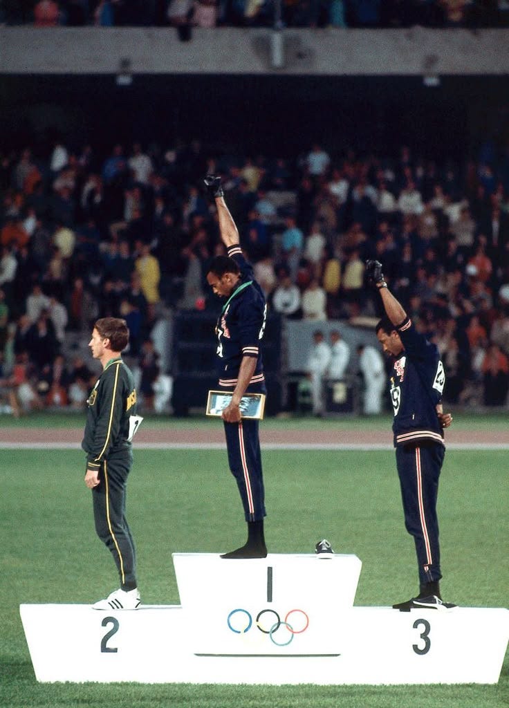 This may contain: three men standing on top of a podium with their hands in the air while one man holds his hand up