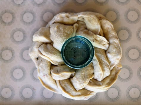 Pictures show process of stuffing challah dough with apples and weaving it into a crown around a jar that is then filled with honney.