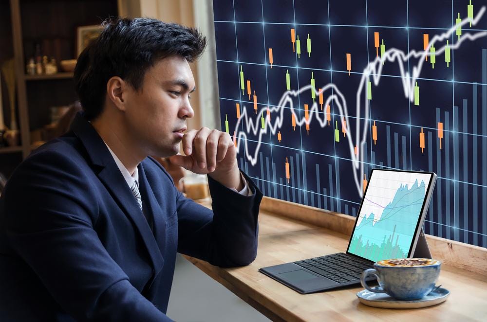 Photo of a man in a suit with a coffee studying a laptop with financial information and graphs Photo of a man in a suit with a coffee studying a laptop with financial information and graphs