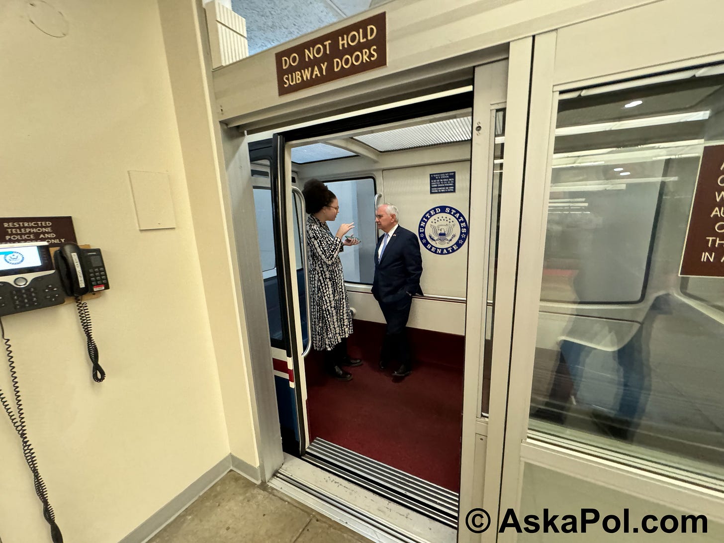 A reporter asks a politician questions on an underground tram before door closes. Photo Matt Laslo © www.askapol.com