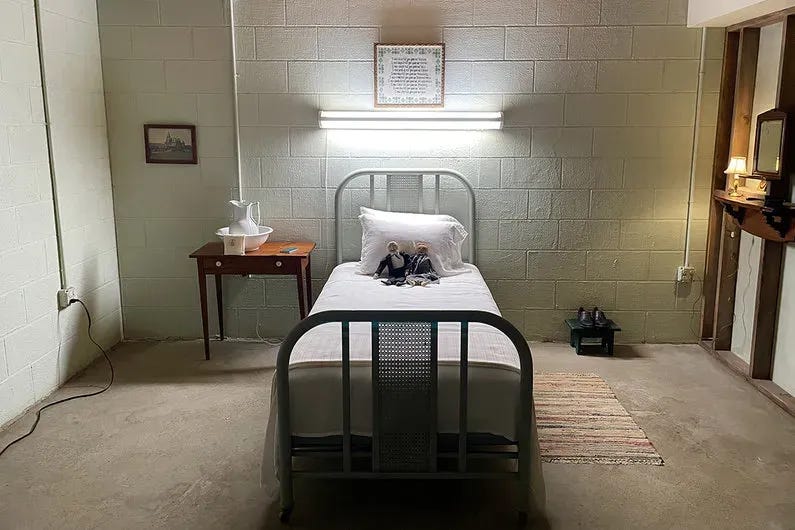 sev_9_cobebed_bed_1_1430.webp Harmony Cobel's bedroom in the house she resided in as Mrs Selvig. There is a single bed with two stuffed figures on it in the middle of a fairly bare room. A cross stitch of Kier Eagan's values hangs above the bed. There is one nightstand with a jug on it.