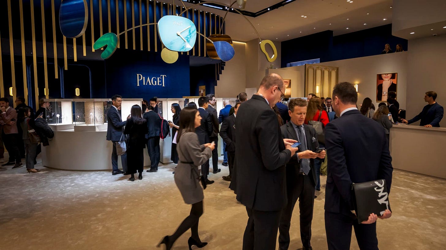 Visitors and salesmen stand at the booth of Swiss luxury watchmaker and jeweler Piaget, during the "Watches and Wonders Geneva" luxury watch fair, on April 1, 2025.