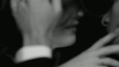 This may contain: black and white photograph of a woman looking at her cell phone with the words love me written on it