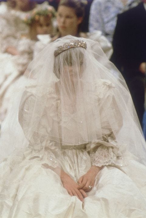This may contain: a woman in a wedding dress sitting down