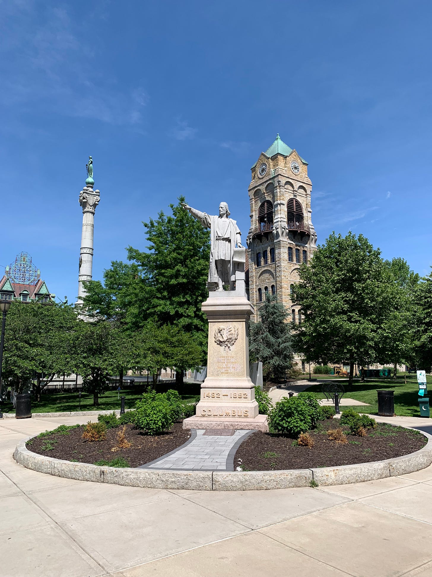 Columbus statue in Scranton town square with "The Electric City" sign in background.