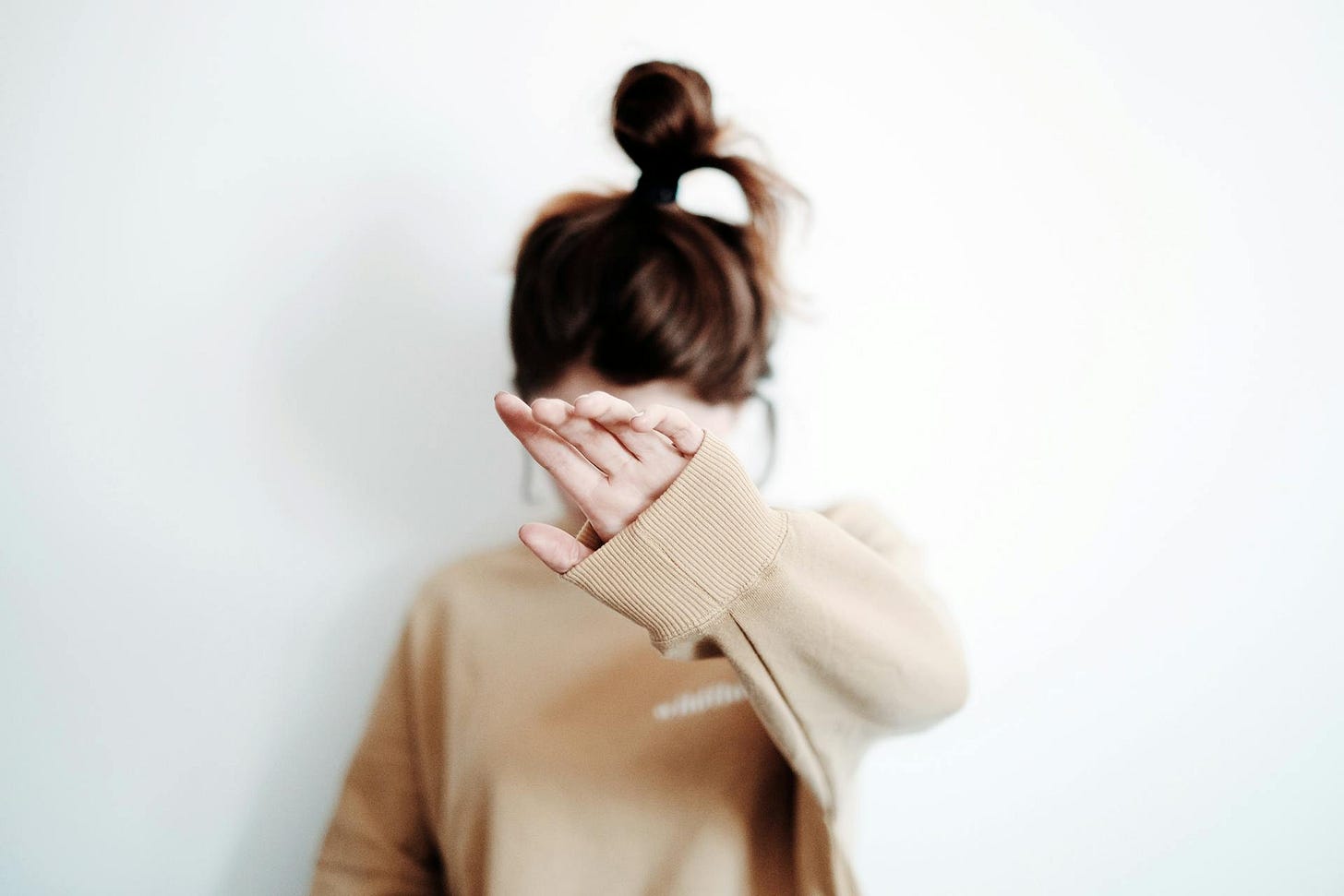 Woman holding up her hand in front of her face Woman holding up her hand in front of her face