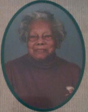 A green oval border outlines a headshot of an older woman, wearing a maroon colored turtleneck shirt