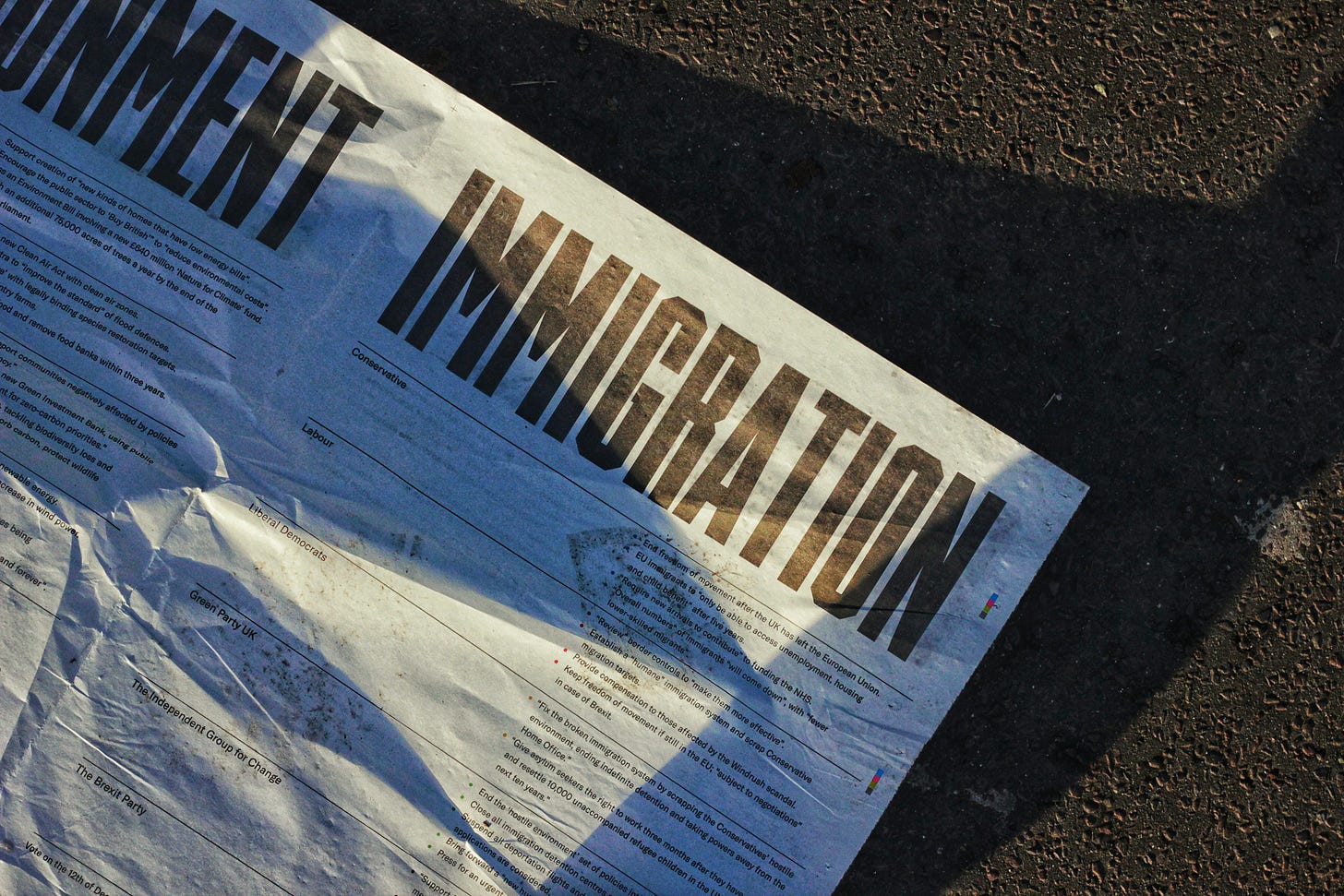 Political propaganda paper lying on the Westminster Bridge, London with a massive headline reading "Immigration" and smaller text underneath detailing political party positions.