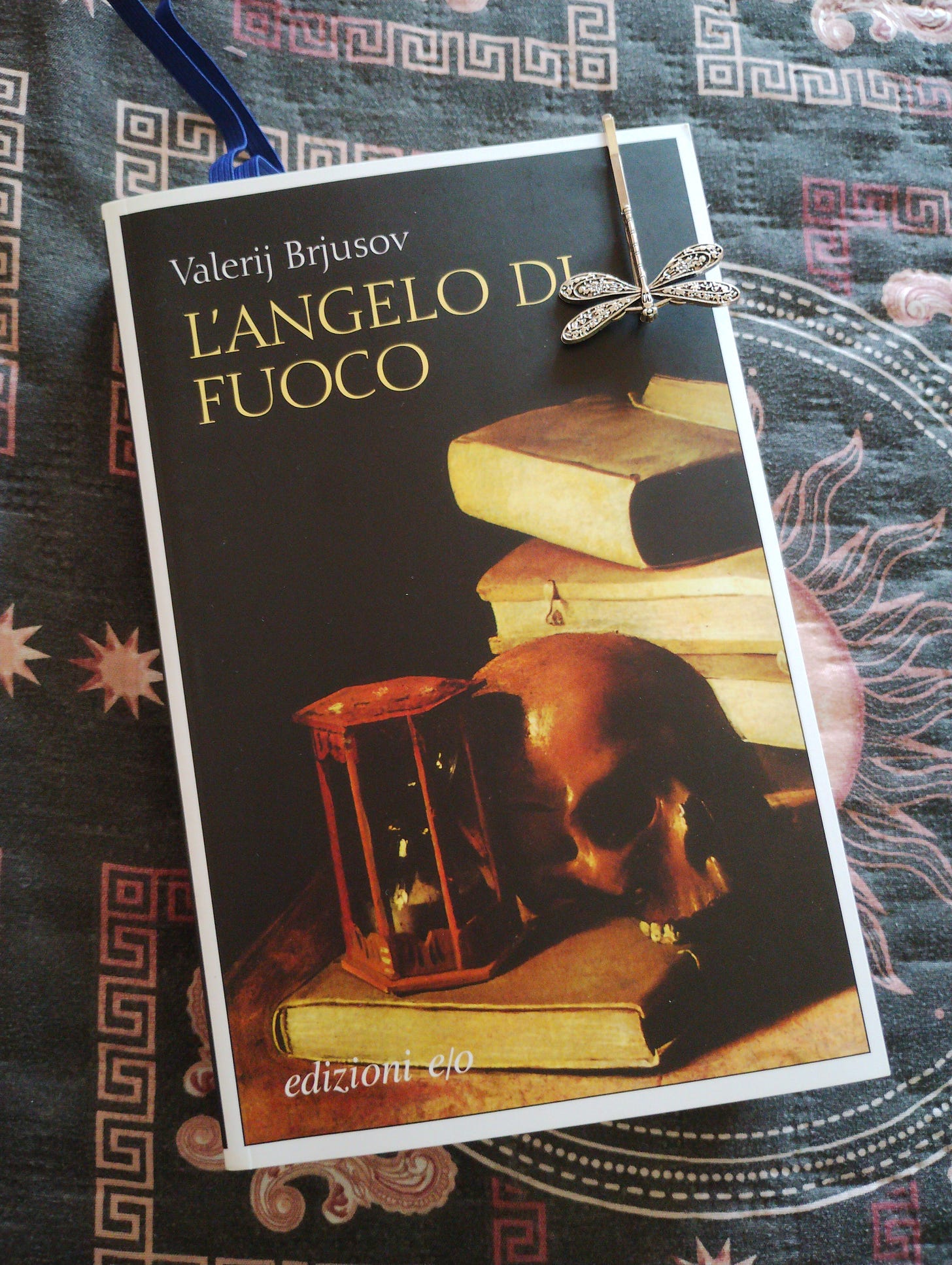 Una foto del libro L'angelo di Fuoco di Valerij Brjusov. In copertina un teschio circondato da libri e da una clessidra.
