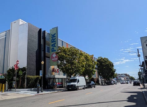 1: Wide street with a large parking garage, 2: Wide 4 lane Beach Street. Multi-level parking  garage on the right, 3: A zoomed photo of the street showing 5 parking signs.