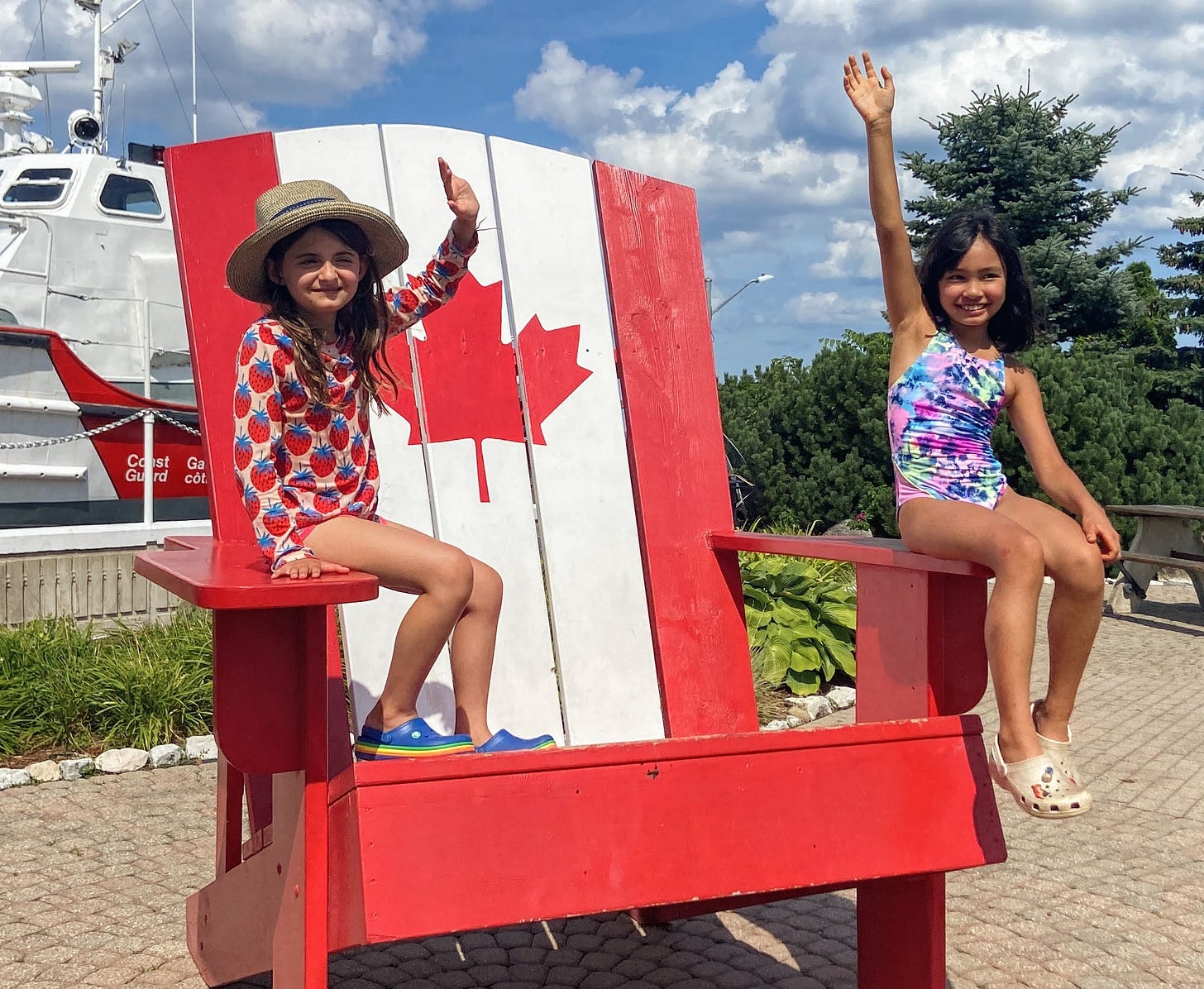 Two children sitting on an oversized Muskoka chair