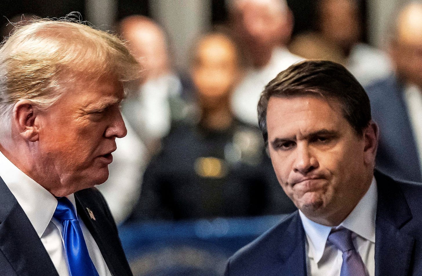 Former U.S. President Trump walks alongside his attorney Todd Blanche