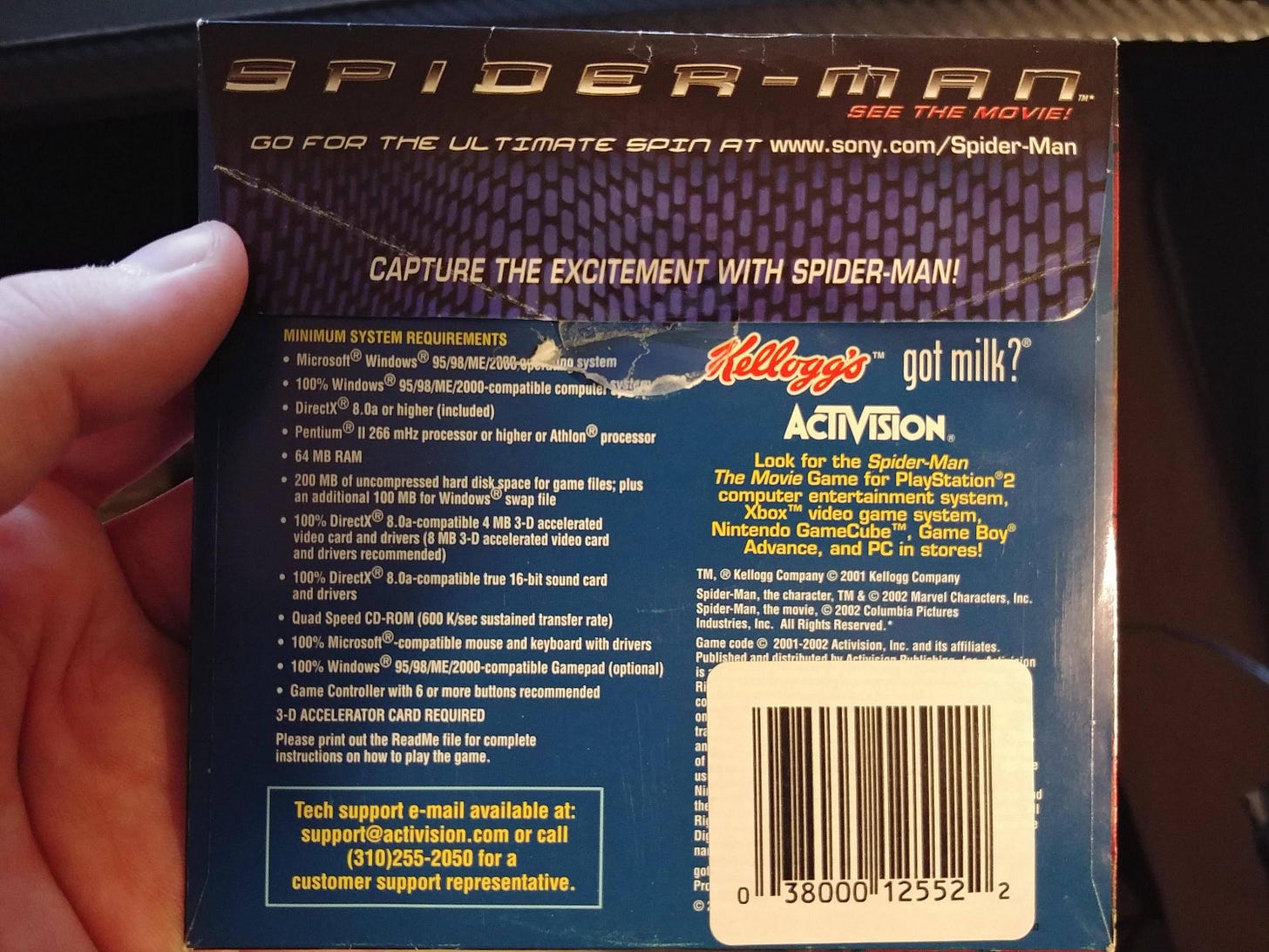 Spider-man DVD disk box in the person's hand, showcasing minimum system requirements. Spider-man DVD disk box in the person's hand, showcasing minimum system requirements.