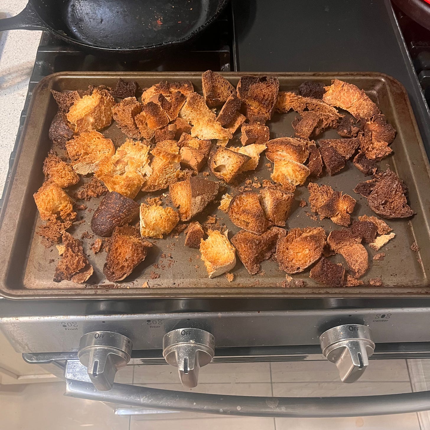a variety of bread chunks toasted on a baking tray on top of the oven a variety of bread chunks toasted on a baking tray on top of the oven