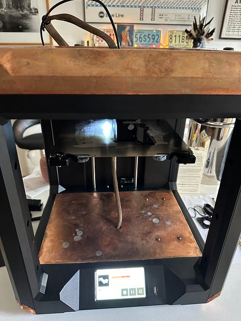 A custom 3D printer designed to look like solar punk, with black 3D printed anatomy models of reproductive organs.