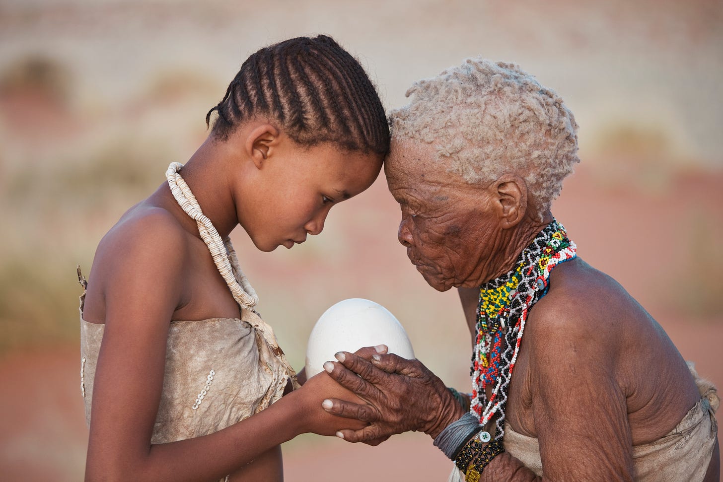 San girl (14yo) given ostrich egg by her grandmother (75yo) in Namibia. Image taken to raise awareness and funds for conservation. Photo by Martin Harvey.
