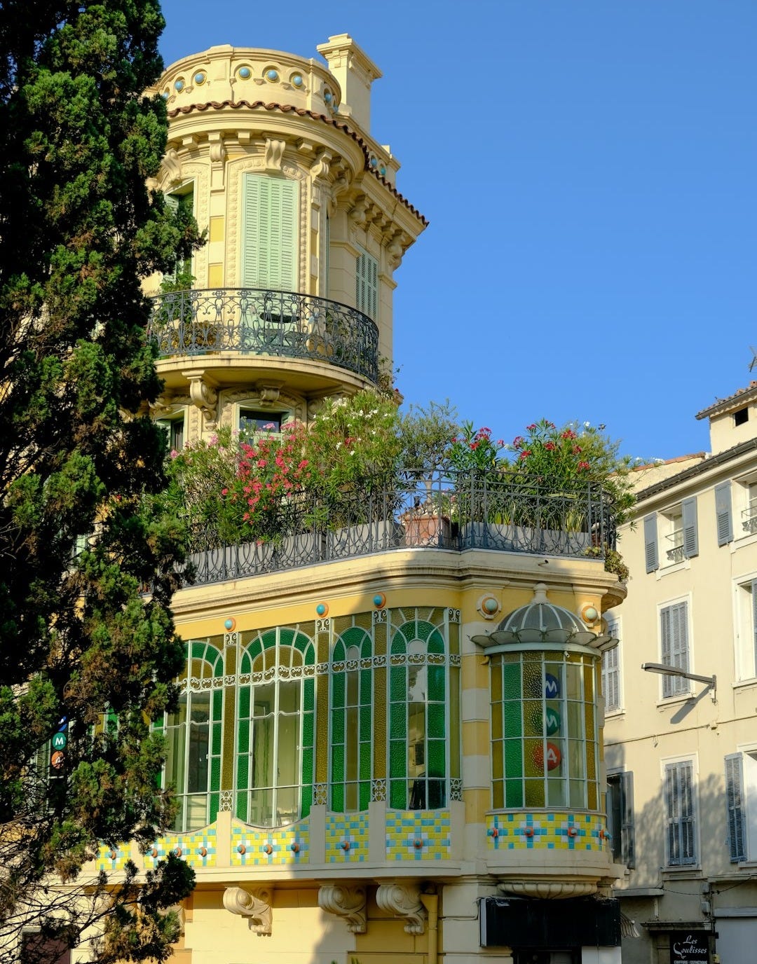 a yellow building with green windows and balconies