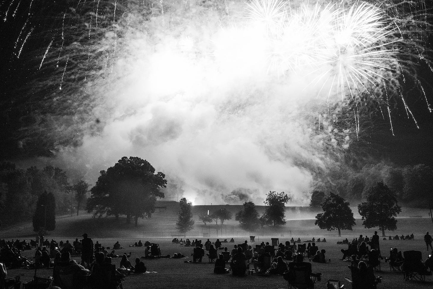 Spectators watch Fourth of July fireworks in East Palestine City Park, sponsored by the fire department. Assistant Chief Rick Gorby, who initially managed the response on the night of the toxic train derailment, oversaw the event.