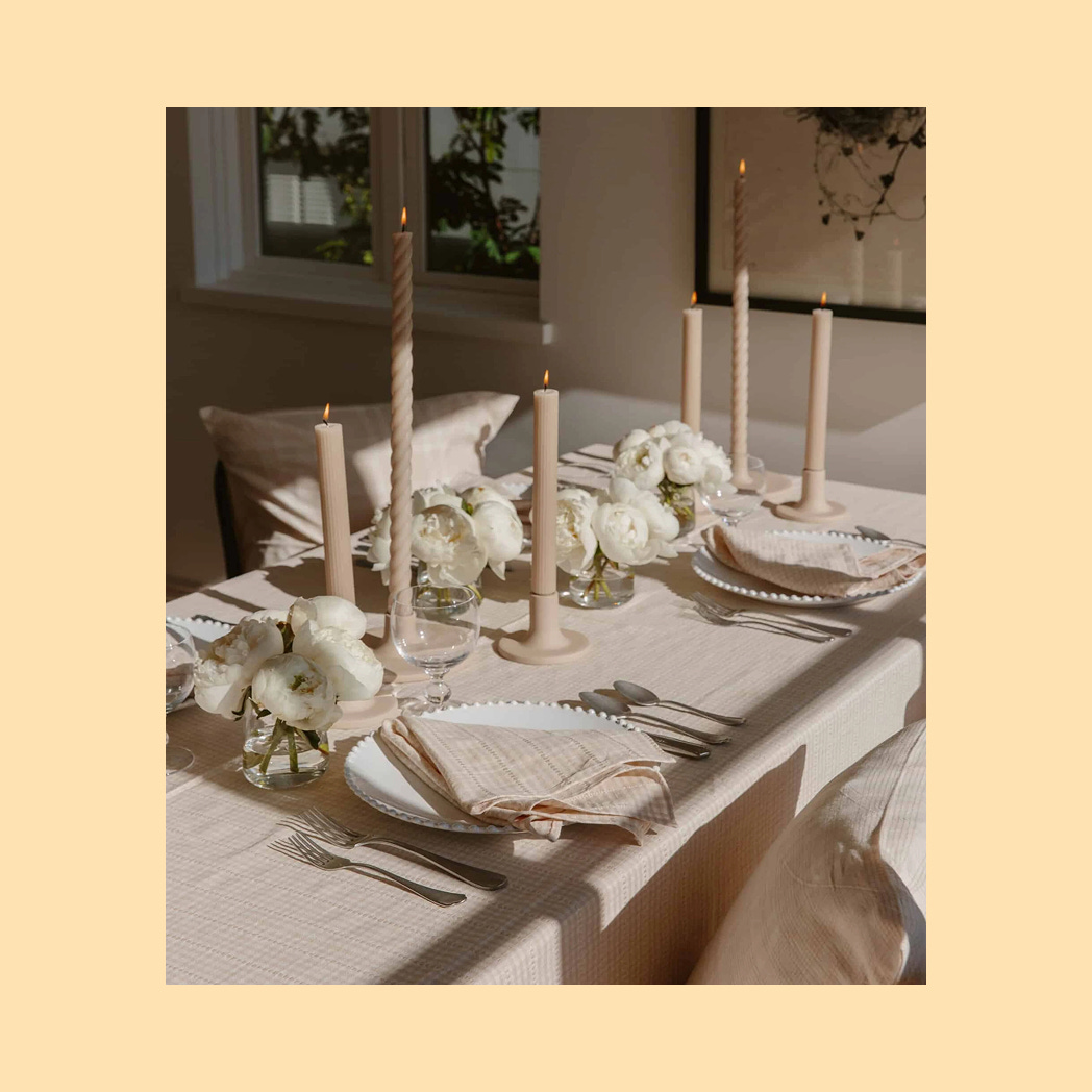 A photo of a monochrome, neutral toned tablescape with a soft linen tablecloth