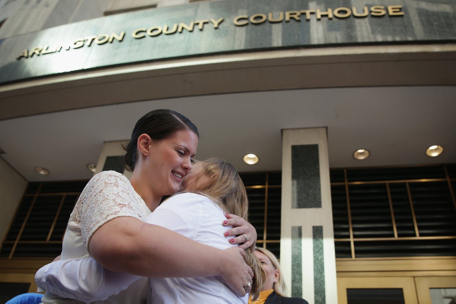 Jennifer Melsop and Erika Turner embrace beneath the Arlington County Courthouse sign after their wedding. Jennifer Melsop and Erika Turner embrace beneath the Arlington County Courthouse sign after their wedding.