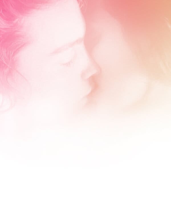 A photo illustration of the faces of two people kissing. They are presented in a wash of pink and peach tones, and fade gradually into a white space. A photo illustration of the faces of two people kissing. They are presented in a wash of pink and peach tones, and fade gradually into a white space.