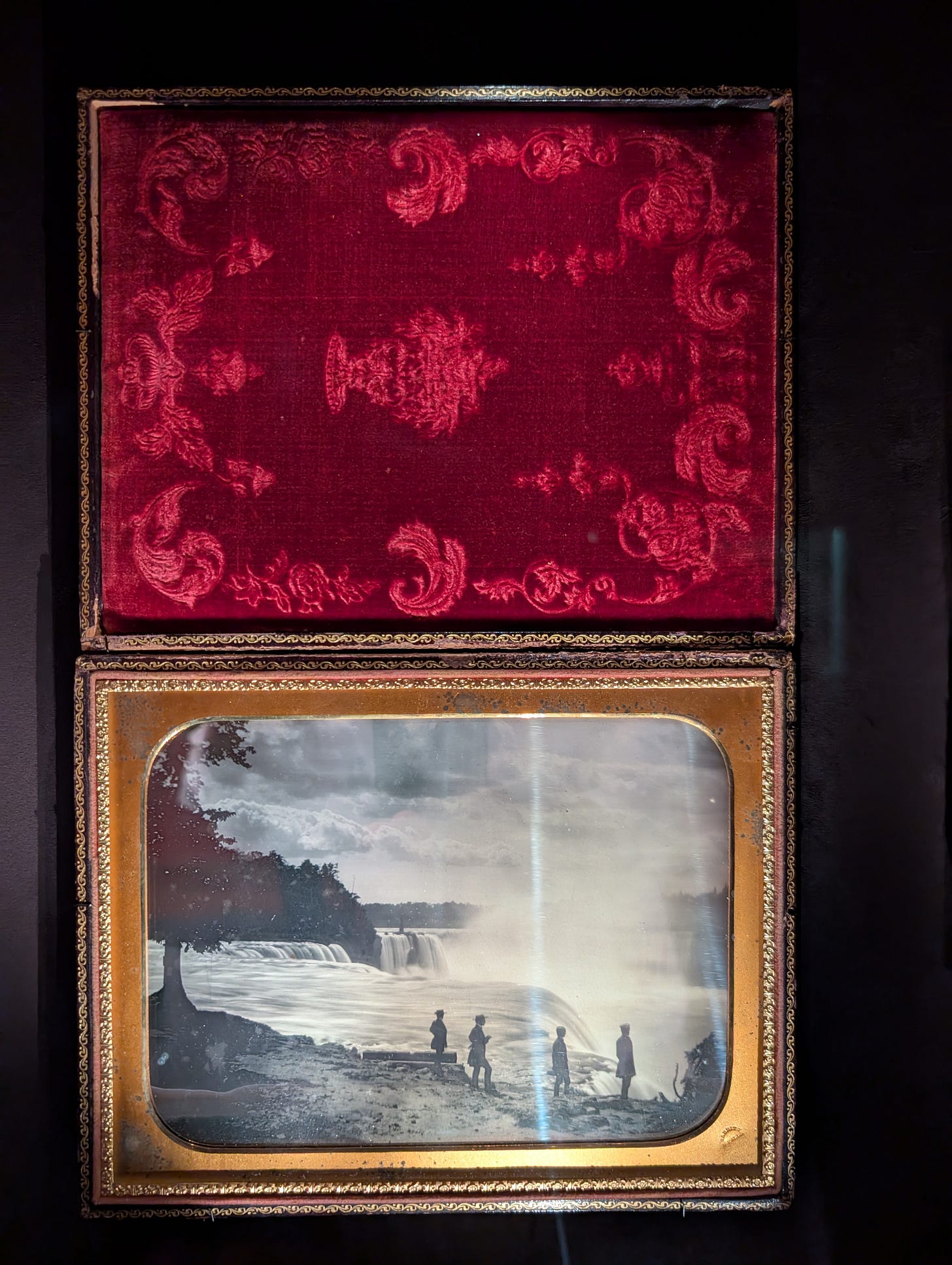 Daguerreotype by Platt D. Babbitt showing silhouetted figures standing near the edge of Niagara Falls, housed in an open velvet-lined case.
