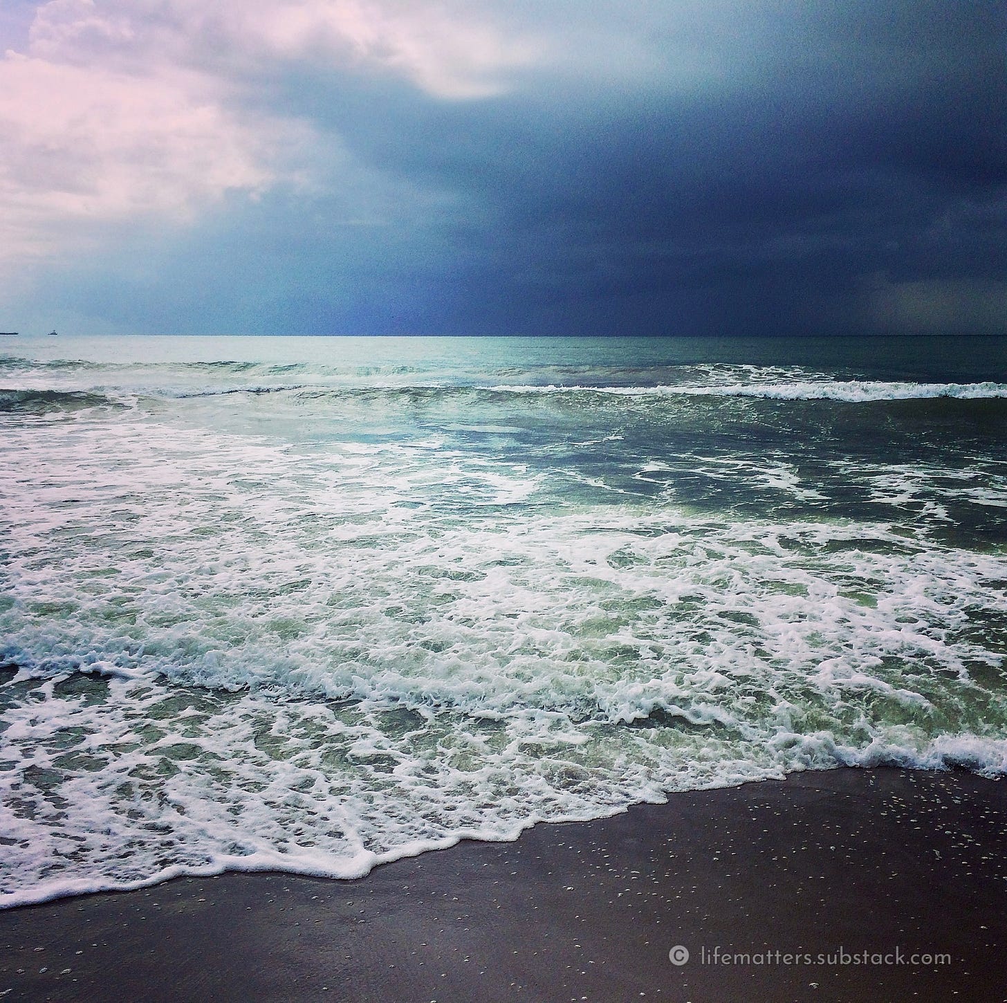Ocean surf with multi-hued sky.