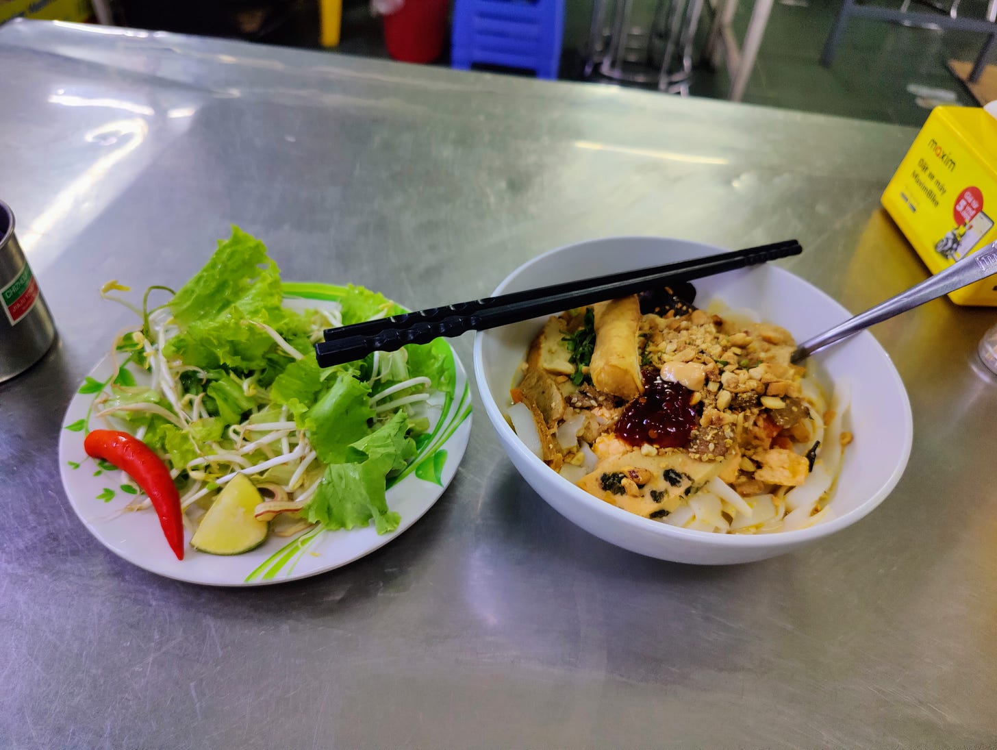 one bowl of greens and bean sprouts, and one bowl of noodles of my quang one bowl of greens and bean sprouts, and one bowl of noodles of my quang