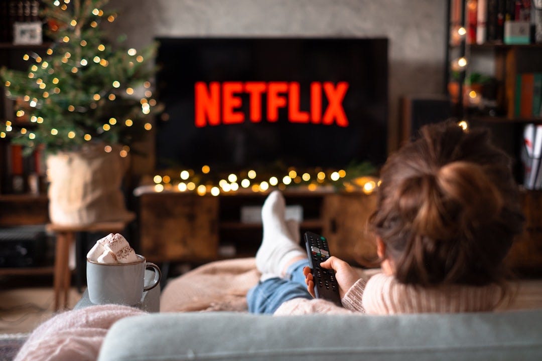 a little girl sitting on a couch watching tv a little girl sitting on a couch watching tv