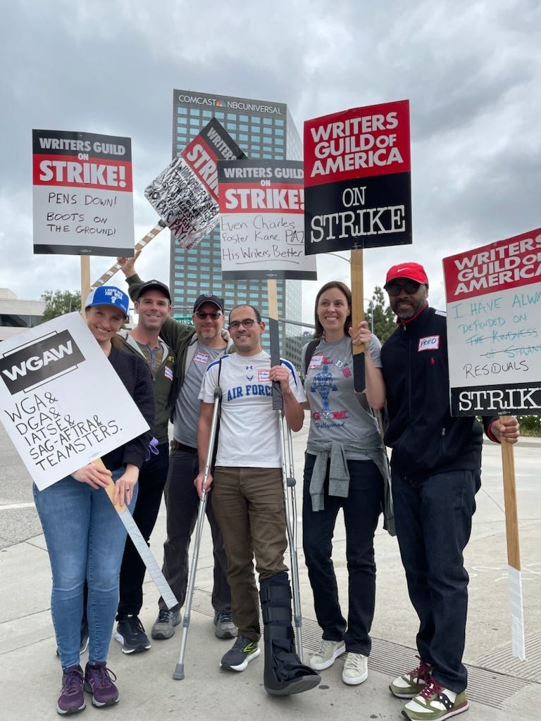 A group of veterans and writers holding "Writers Guild of America on Strike" signs in front of the Comcast/NBC Universal building in Studio City. A group of veterans and writers holding "Writers Guild of America on Strike" signs in front of the Comcast/NBC Universal building in Studio City.