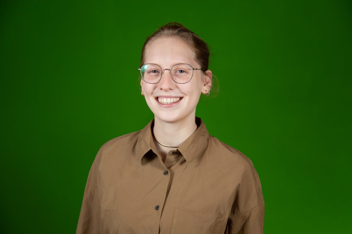 A person wearing glasses and a brown shirt

Description automatically generated