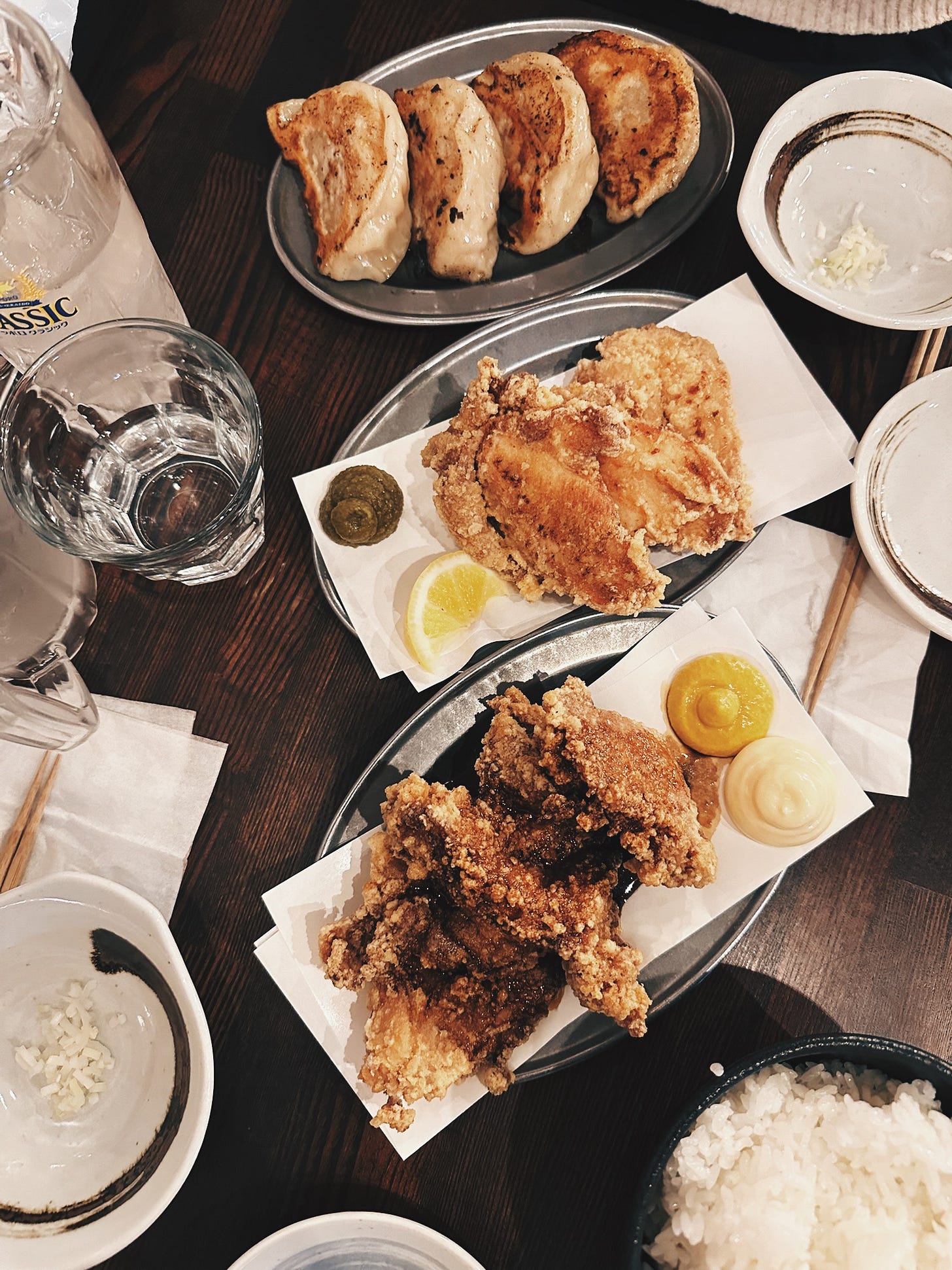 Full table spread of zangi and gyoza on pewter trays at Sapporo Gyoza Seizo Sho Tanakiji Ten, with Sapporo Classic Lemon Sour. Full table spread of zangi and gyoza on pewter trays at Sapporo Gyoza Seizo Sho Tanakiji Ten, with Sapporo Classic Lemon Sour.