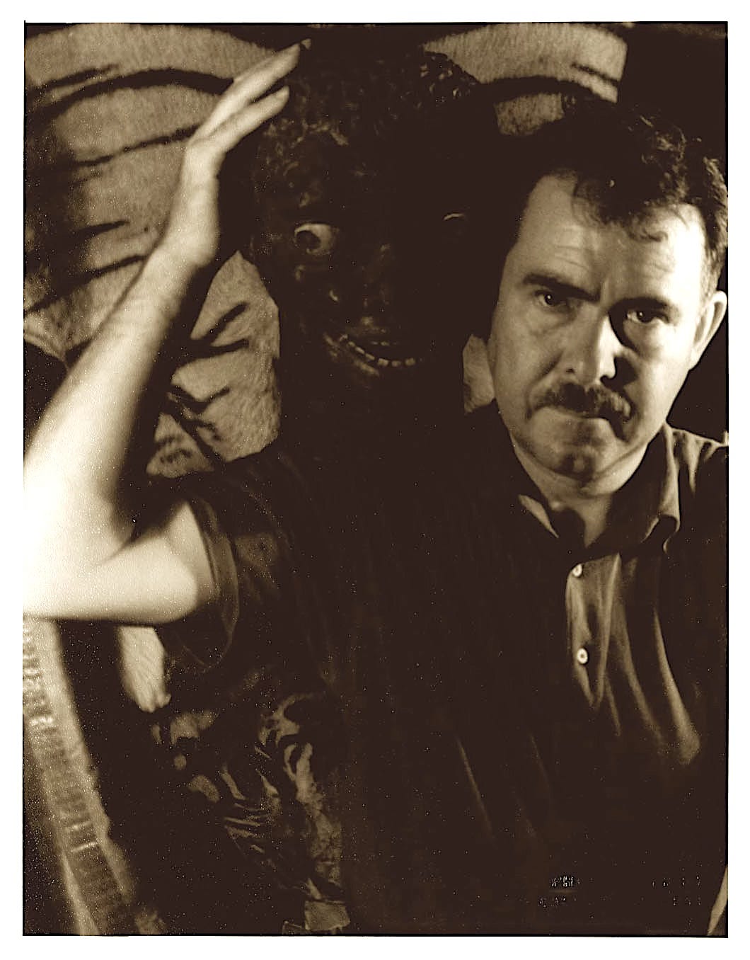 Black and White Portrait of William Seabrook with his hand on some sort of death visage, presumably an African or Caribbean artifact.