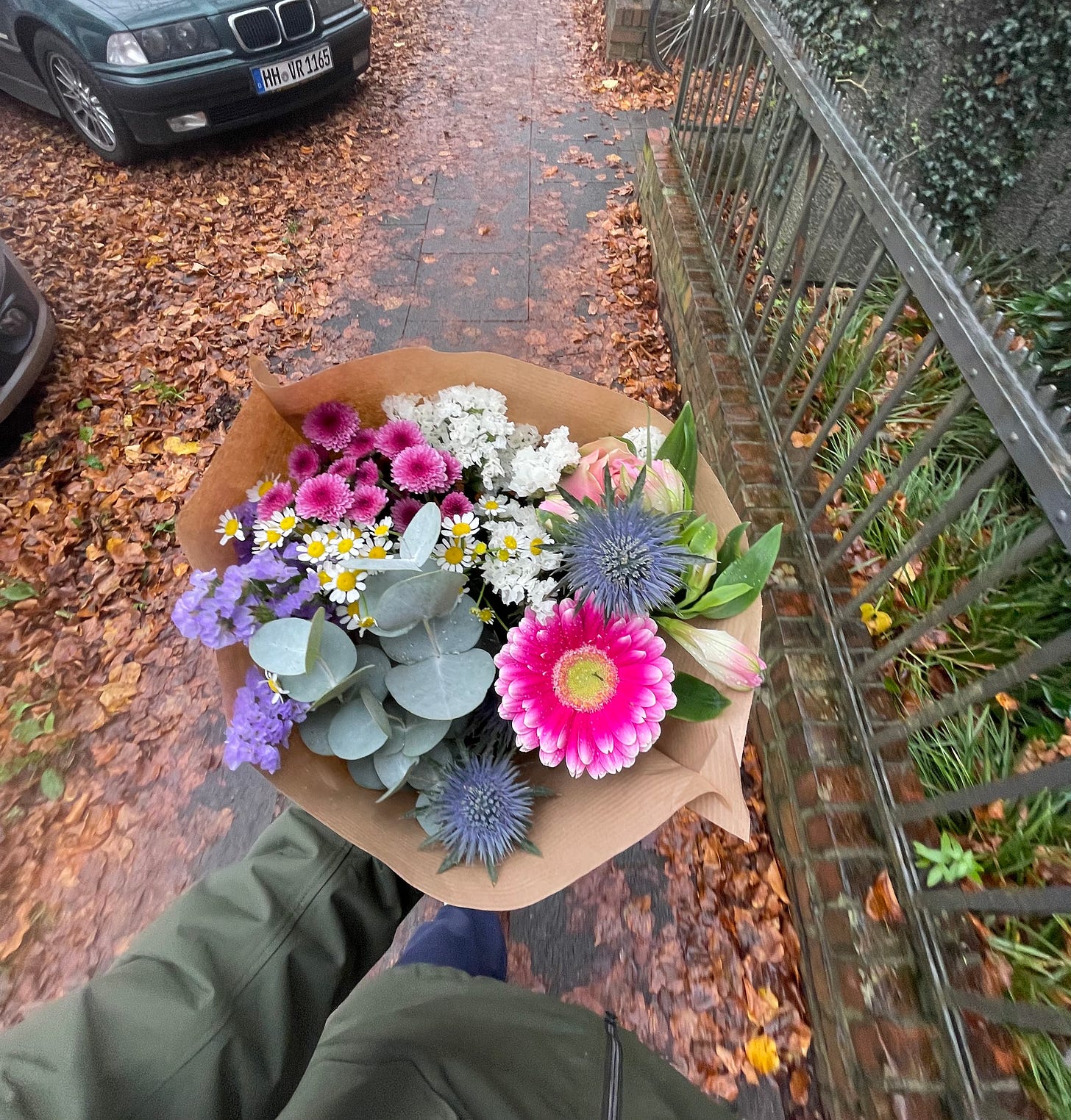 Looking down on a beautiful bouquet of flowers while walking over autumn leaves on the ground