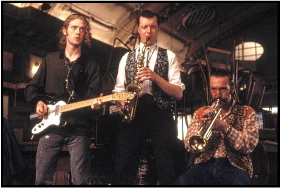 Outspan, Dean, and Joey "The Lips" rehearse a song in a scene from the movie, "The Commitments."